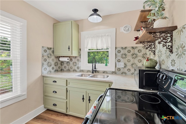 kitchen with range with electric stovetop, light hardwood / wood-style flooring, sink, and green cabinets