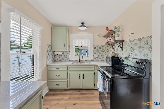 kitchen featuring green cabinets, light hardwood / wood-style floors, sink, and black range with electric stovetop