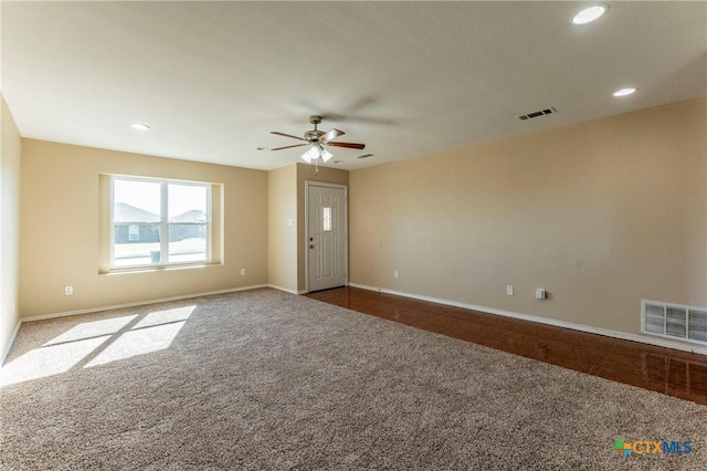 carpeted spare room featuring ceiling fan