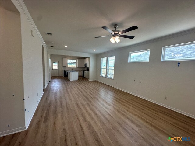 unfurnished living room with hardwood / wood-style floors, ceiling fan, and crown molding