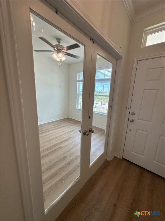 entryway featuring hardwood / wood-style flooring, ceiling fan, french doors, and ornamental molding