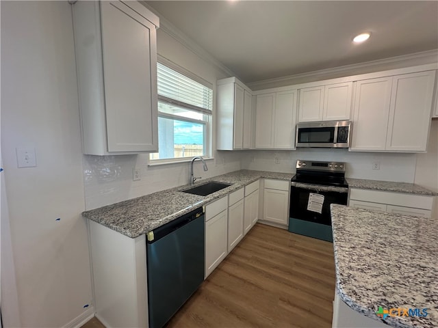 kitchen with crown molding, stainless steel appliances, white cabinetry, dark hardwood / wood-style flooring, and sink