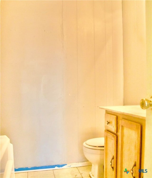 bathroom with tile patterned flooring, vanity, and toilet