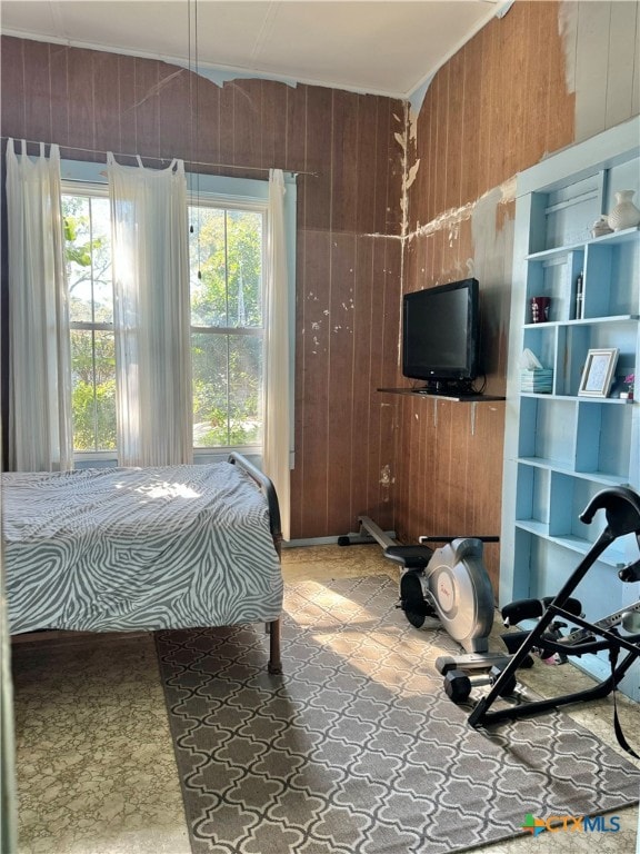 bedroom featuring wooden walls