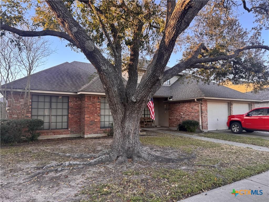 304 Dunbar Dr, Victoria, TX 77904 - view of front of home featuring brick siding, an attached garage, and a shingled roof