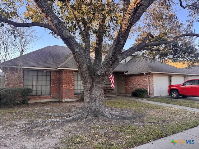 304 Dunbar Dr, Victoria, TX 77904 - view of front of home featuring brick siding, an attached garage, and a shingled roof