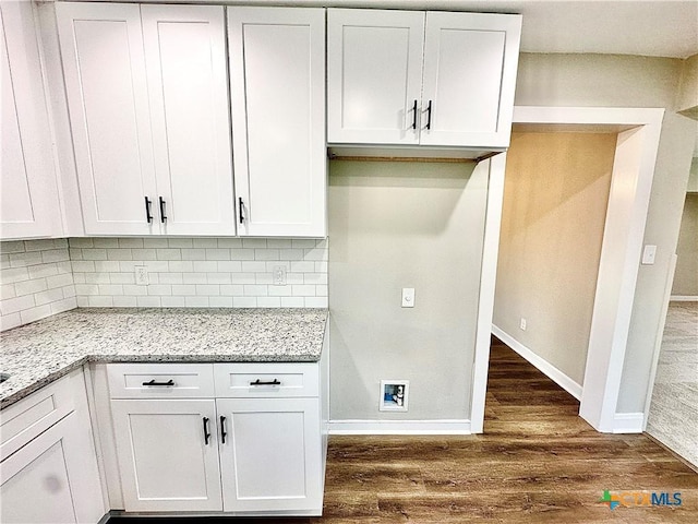 kitchen featuring decorative backsplash, white cabinetry, dark wood-type flooring, and light stone countertops