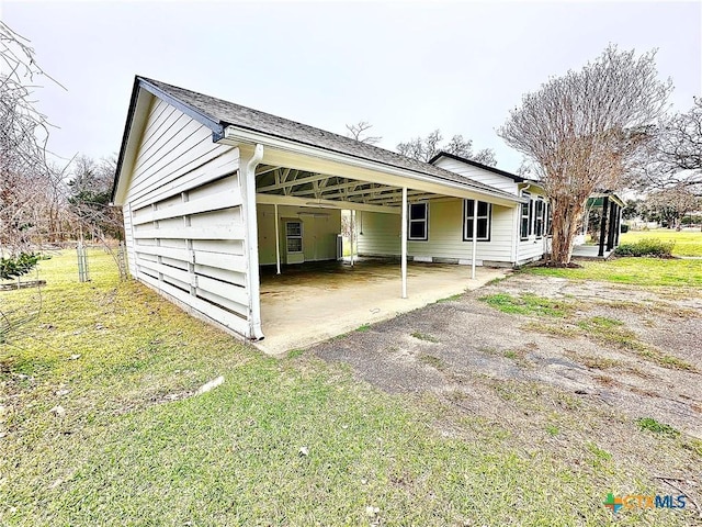 view of property exterior featuring a carport and a lawn