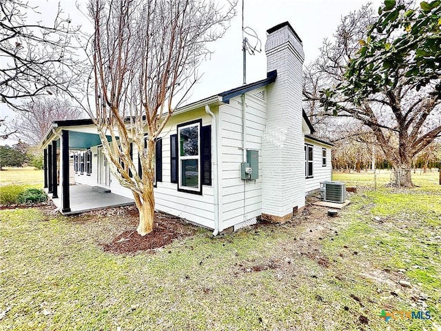 view of property exterior featuring central air condition unit, a patio, and a yard