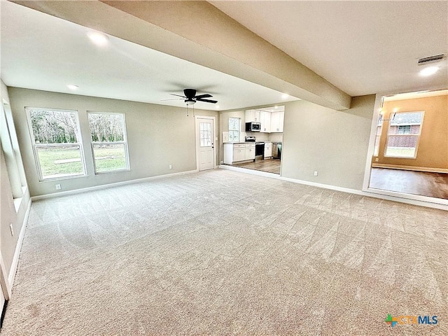 unfurnished living room featuring ceiling fan and carpet