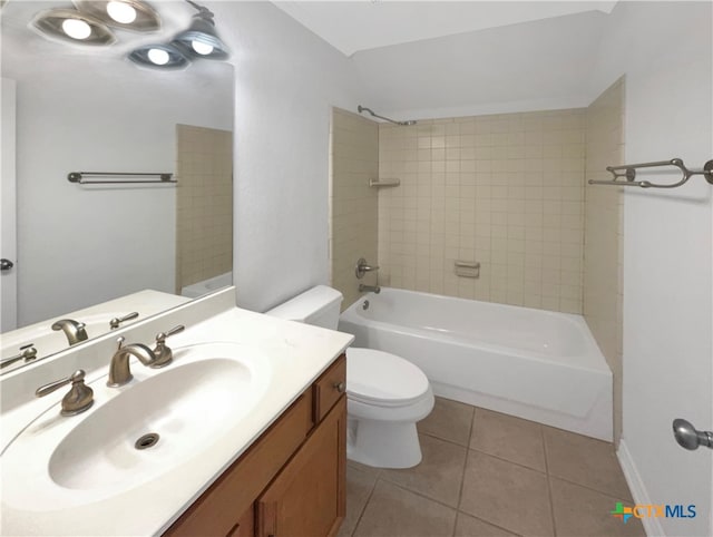 full bathroom featuring vanity, tile patterned flooring, toilet, and tiled shower / bath