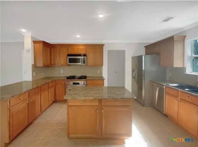 kitchen with ornamental molding, kitchen peninsula, appliances with stainless steel finishes, and light stone counters