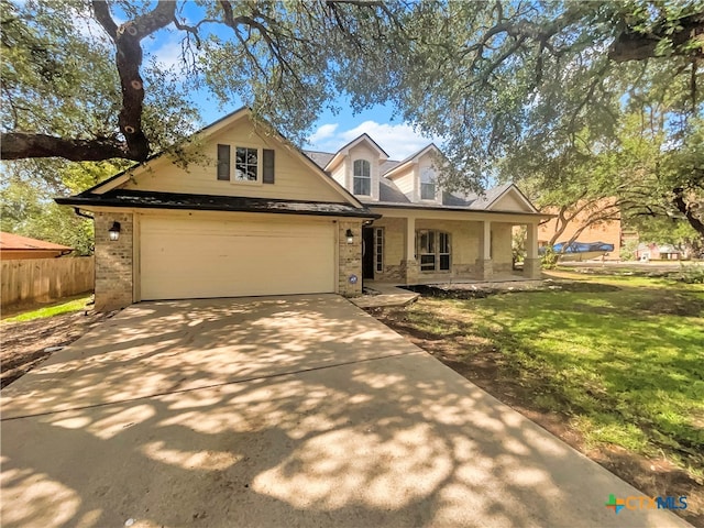 view of front of home with a garage, a front lawn, and a porch