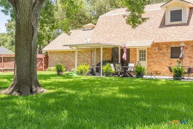 3309 Cottonwood Ln, Temple, TX 76502 - back of house featuring a shingled roof, brick siding, and a patio