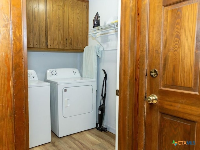 3309 Cottonwood Ln, Temple, TX 76502 - laundry room with cabinet space, washing machine and dryer, and light wood-style floors