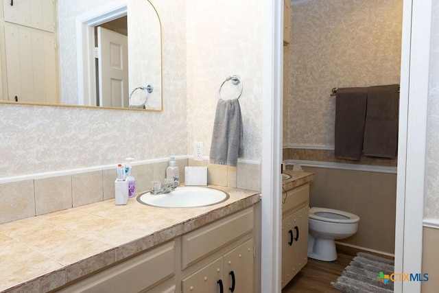 3309 Cottonwood Ln, Temple, TX 76502 - bathroom with wallpapered walls, vanity, and wood finished floors