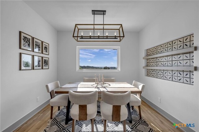 438 Cedar Mountain Dr, Marble Falls, TX 78654 - dining space with light wood-style floors, baseboards, and a chandelier