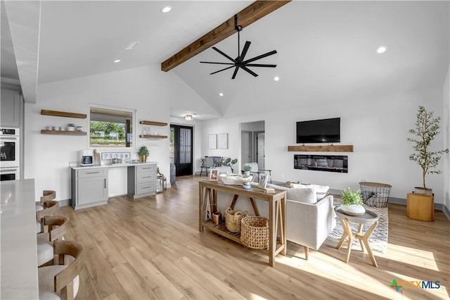 438 Cedar Mountain Dr, Marble Falls, TX 78654 - living room featuring ceiling fan, beam ceiling, a glass covered fireplace, high vaulted ceiling, and light wood-type flooring