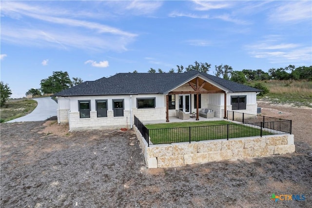 438 Cedar Mountain Dr, Marble Falls, TX 78654 - back of property featuring an outdoor hangout area, stone siding, a patio area, a shingled roof, and driveway