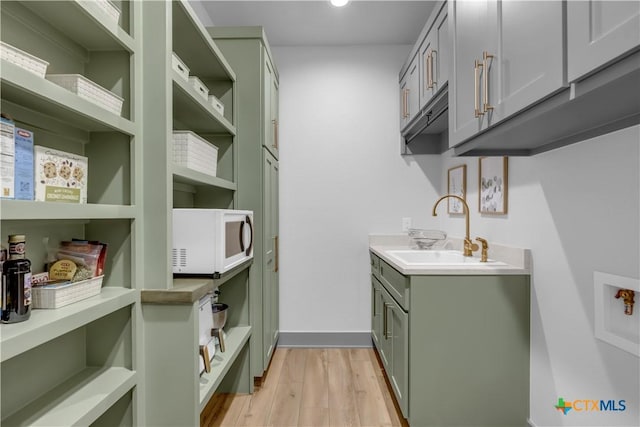 438 Cedar Mountain Dr, Marble Falls, TX 78654 - clothes washing area with a sink, light wood-style floors, recessed lighting, and baseboards
