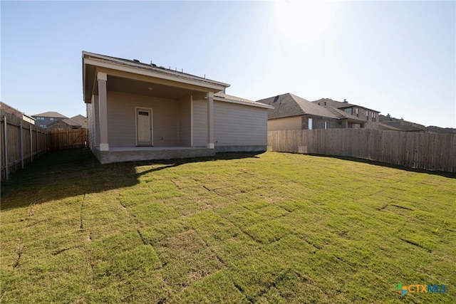 back of house featuring a patio area and a lawn