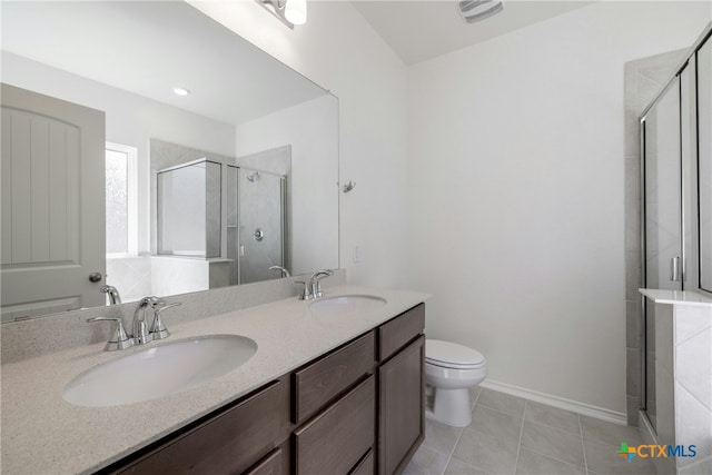 bathroom with tile patterned flooring, vanity, toilet, and a shower with door