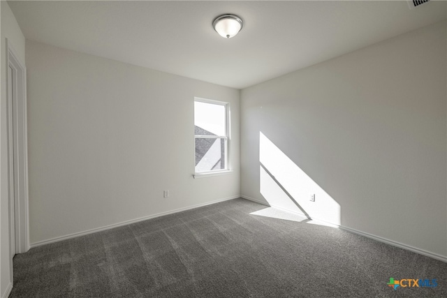 empty room with dark colored carpet