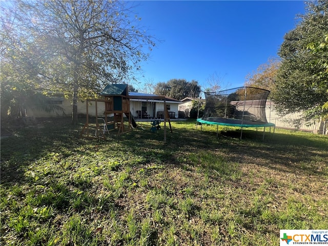 view of yard with a playground and a trampoline