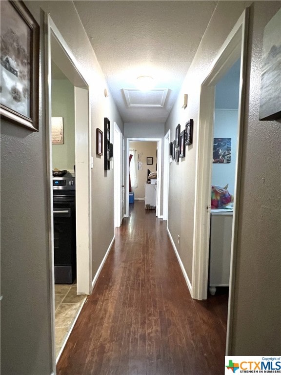 corridor featuring wood-type flooring and a textured ceiling