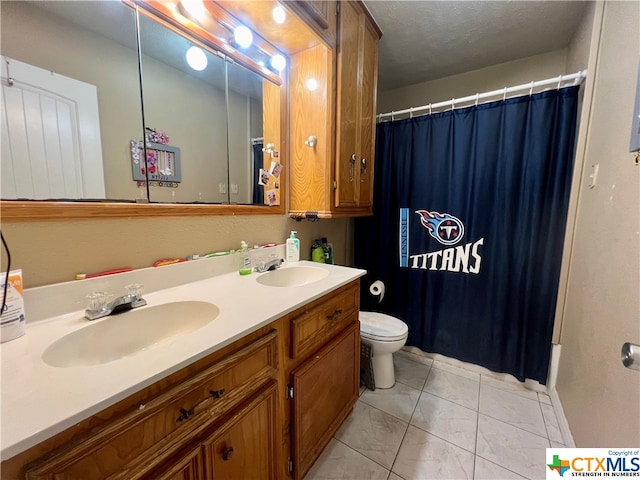 bathroom featuring toilet, vanity, and a textured ceiling