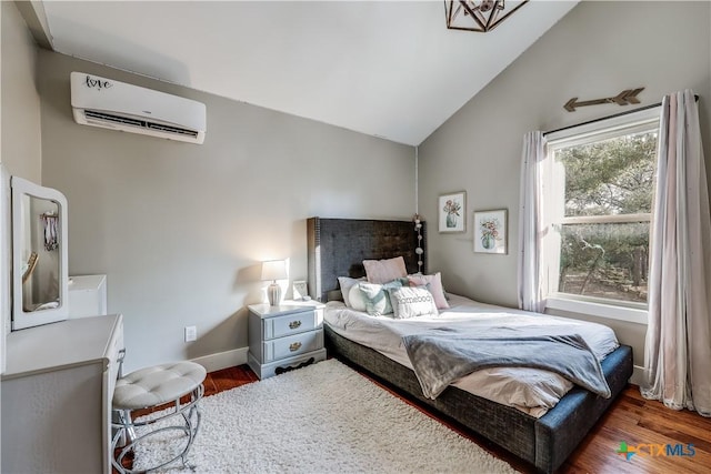 bedroom featuring a wall unit AC, vaulted ceiling, and dark hardwood / wood-style floors