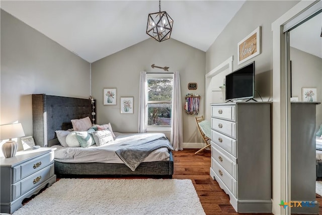 bedroom featuring a chandelier, dark hardwood / wood-style flooring, and vaulted ceiling