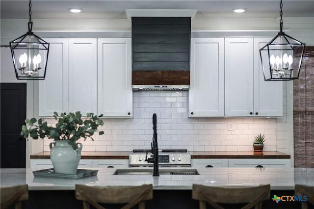 kitchen featuring backsplash, white cabinetry, and decorative light fixtures