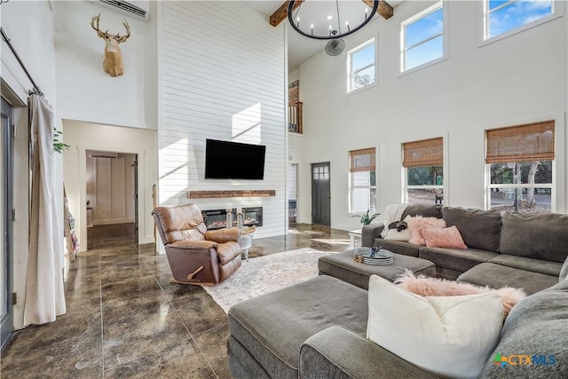 living room with beam ceiling, plenty of natural light, a fireplace, and a high ceiling