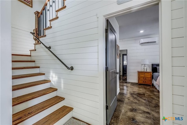 stairs with wood walls and a wall unit AC