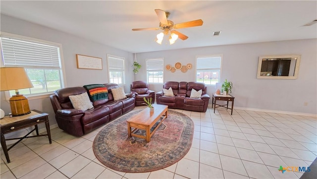 living room with a wealth of natural light, light tile patterned floors, and ceiling fan