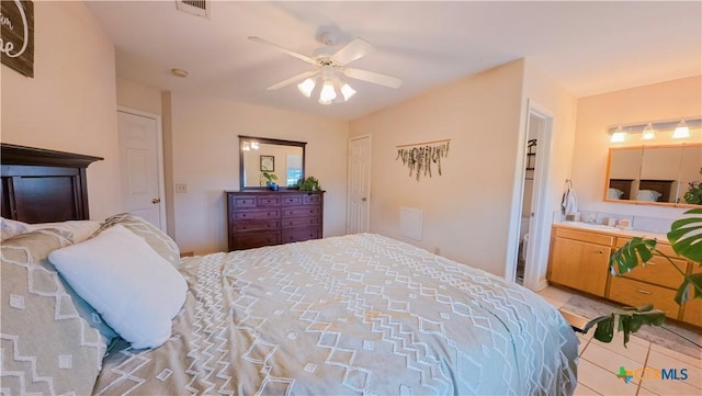 tiled bedroom featuring ensuite bath and ceiling fan