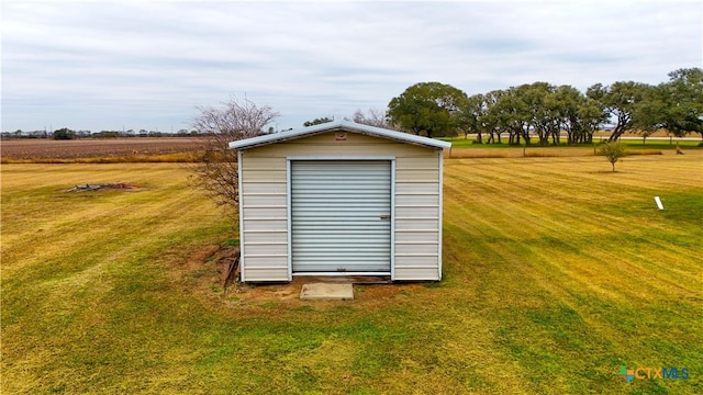 view of outdoor structure with a rural view and a lawn