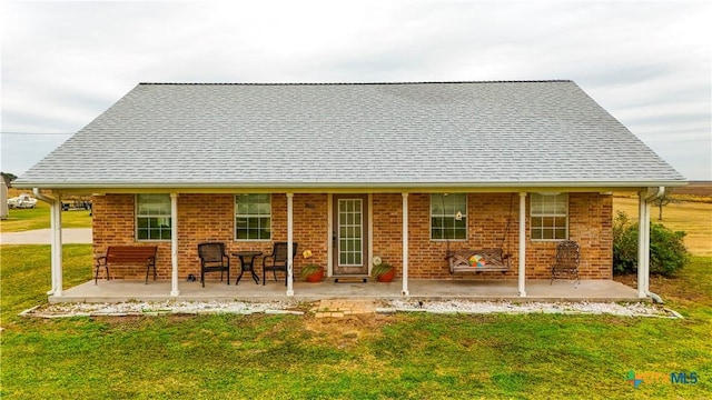 rear view of property featuring a lawn and a patio