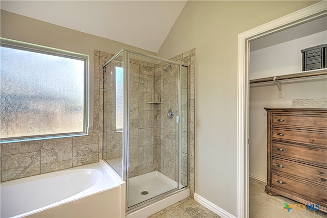 bathroom featuring tile patterned flooring, lofted ceiling, and separate shower and tub