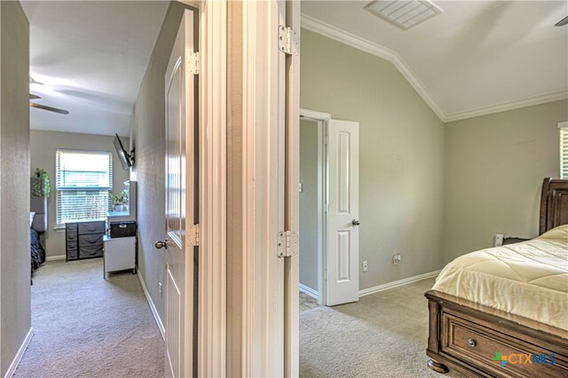 bedroom featuring ornamental molding, lofted ceiling, and light carpet