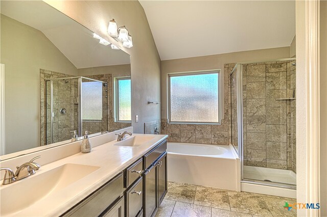 bathroom featuring vanity, separate shower and tub, and lofted ceiling