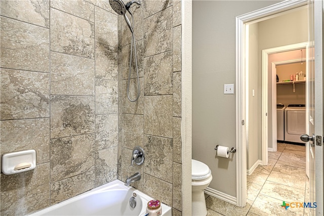 bathroom with washing machine and dryer, toilet, and tiled shower / bath combo