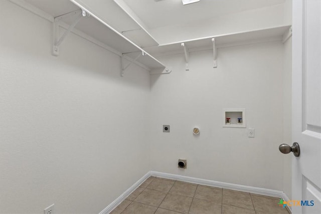 7778 Little Deer Trl, Georgetown, TX 78628 - laundry area with laundry area, hookup for an electric dryer, light tile patterned floors, washer hookup, and baseboards