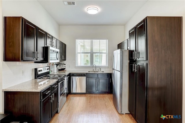 2400 Louis Henna Blvd Unit 305, Round Rock, TX 78664 - kitchen with a sink, stainless steel appliances, light wood-type flooring, tasteful backsplash, and visible vents