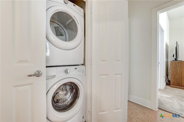 2400 Louis Henna Blvd Unit 305, Round Rock, TX 78664 - clothes washing area with laundry area, stacked washer and dryer, light wood-style flooring, and baseboards