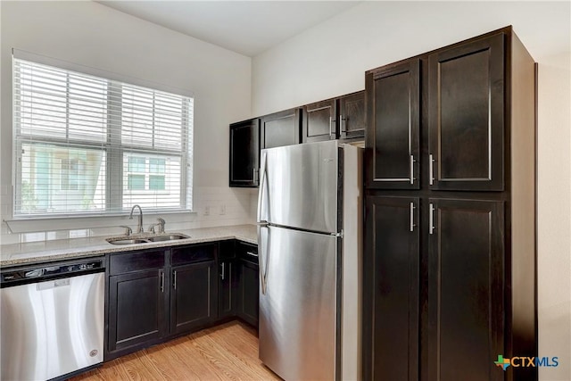 2400 Louis Henna Blvd Unit 305, Round Rock, TX 78664 - kitchen featuring light stone countertops, dark brown cabinets, a sink, light wood-style floors, and stainless steel appliances