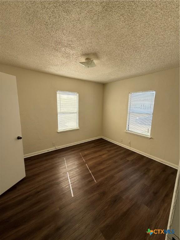 carpeted empty room with a textured ceiling, plenty of natural light, and ceiling fan