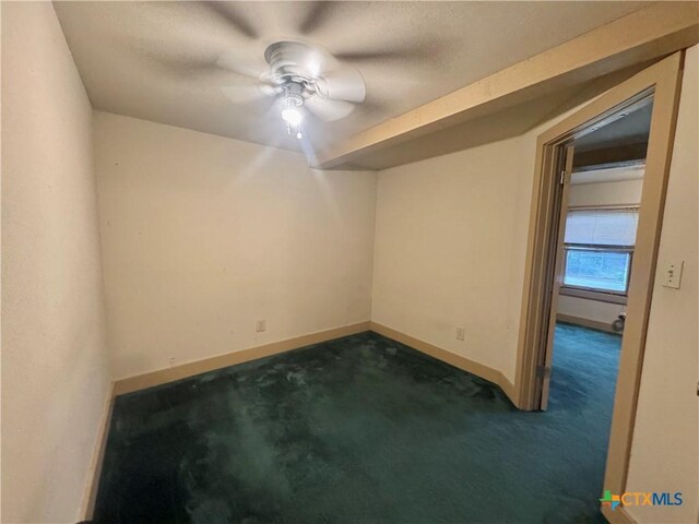 503 Dunn St, Yoakum, TX 77995 - spare room with a ceiling fan, dark colored carpet, and baseboards
