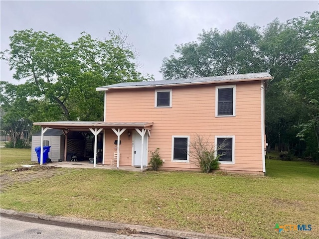 503 Dunn St, Yoakum, TX 77995 - traditional-style home featuring a front yard, metal roof, and an attached carport